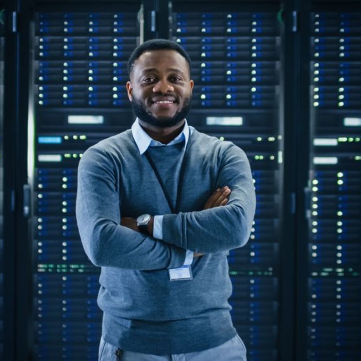 Data Engineer standing in front of servers.  